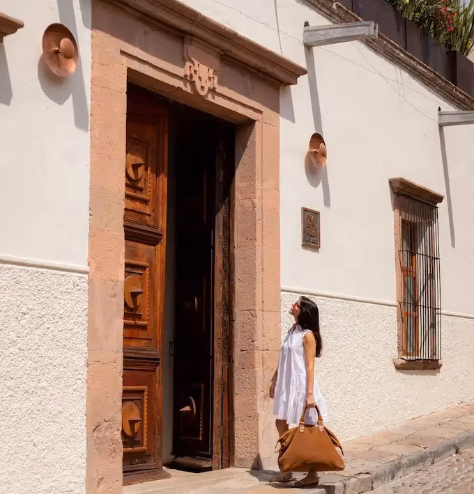Traveler arriving at the historic facade and monumental entrance of La Valise San Miguel Hotel in San Miguel de Allende.