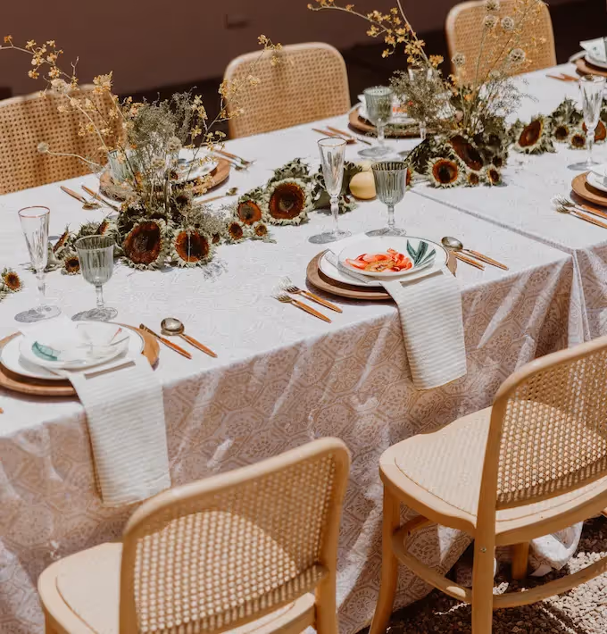 Elegant reception table setting with floral centerpieces and rattan chairs at La Valise San Miguel Hotel restaurant.