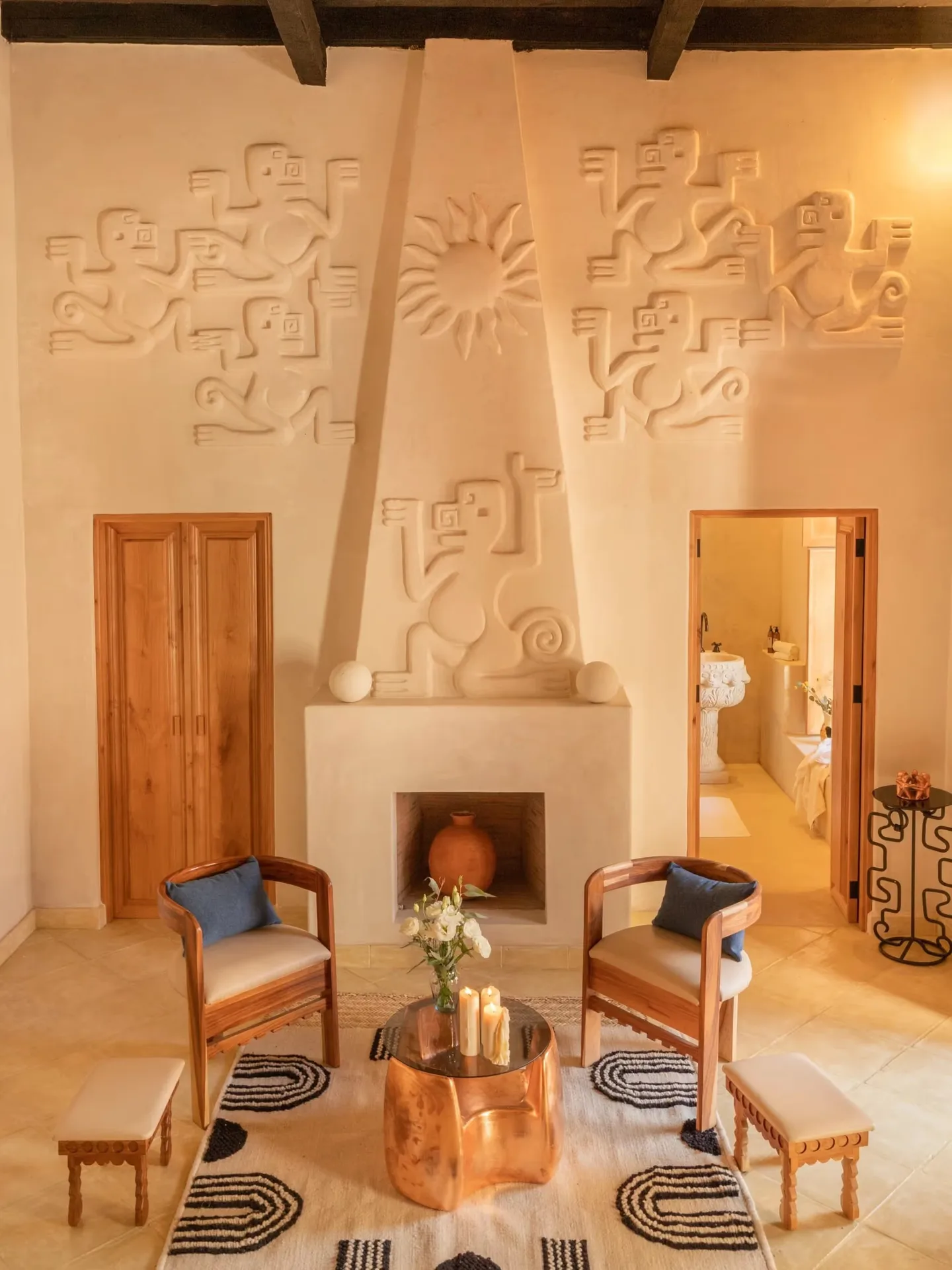 Sala de estar de prestigio con chimenea y tallas artísticas en la pared en La Valise San Miguel Hotel.