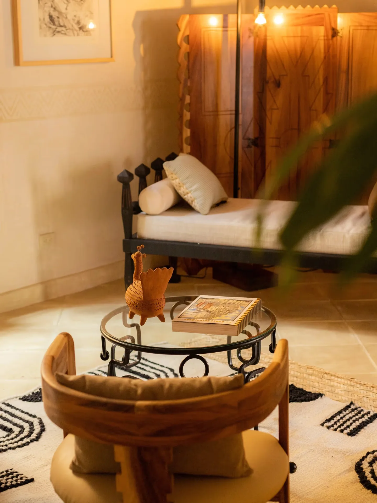 Acogedora sala de estar con silla de diseño, mesa de centro de hierro forjado y tapete gráfico en una habitación de La Valise San Miguel Hotel.
