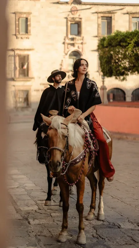 Riders on horseback in the cobbled streets of San Miguel de Allende — Explore stream of The Voyage Within