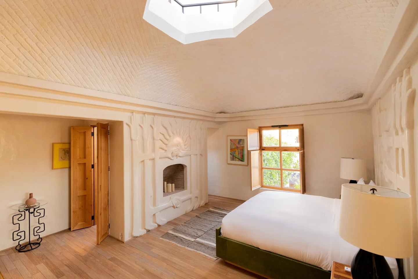Recámara de la Master Suite con chimenea en esquina, techo abovedado de ladrillo y tragaluz octagonal — La Valise San Miguel de Allende