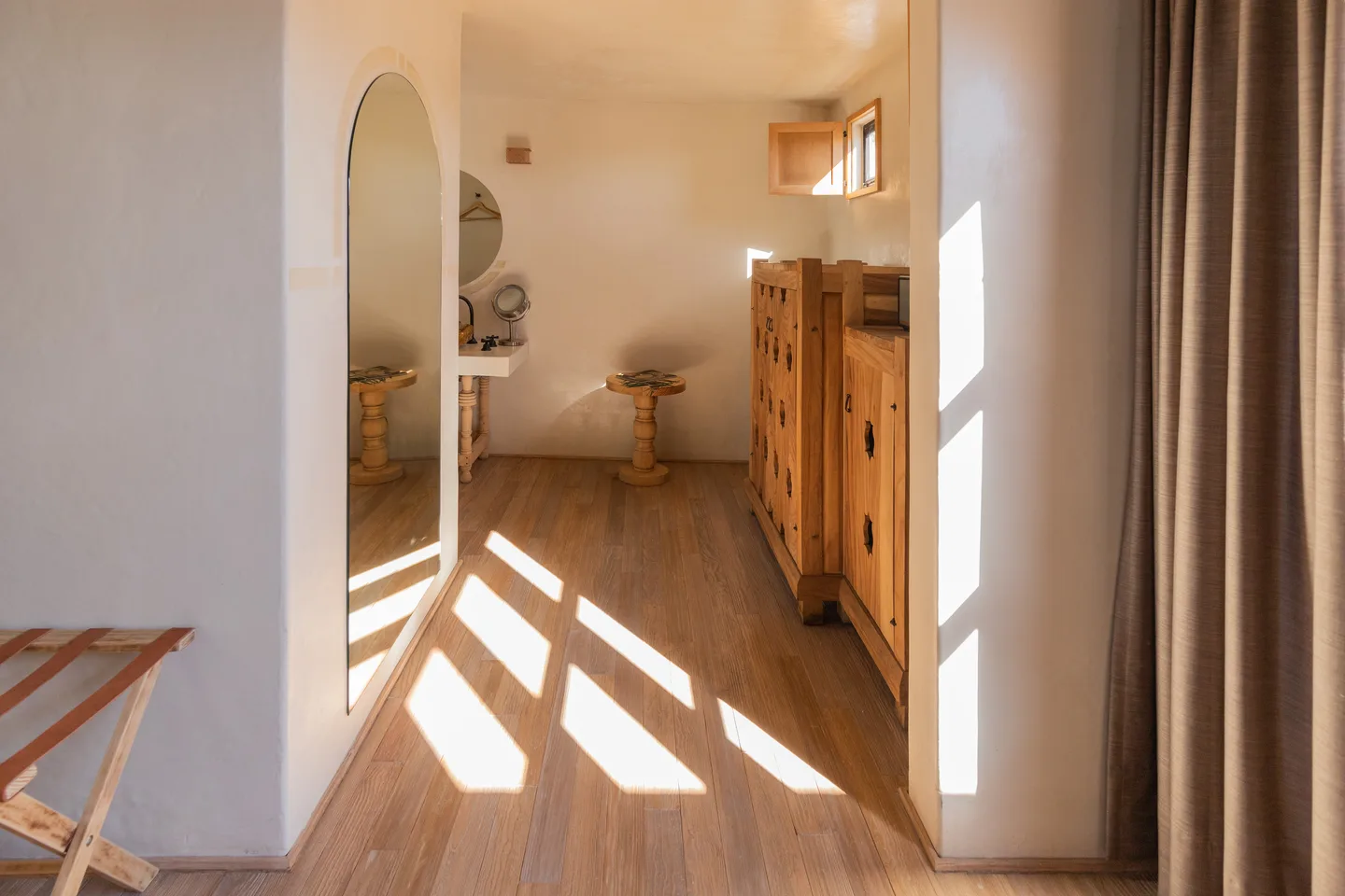 Vestidor iluminado por el sol con armario de madera tallada en la Aura Suite — La Valise San Miguel de Allende