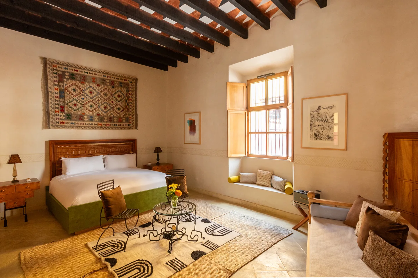 Cóatl Suite with carved wooden bed, woven wall textile, window seat and wood-beamed ceiling — La Valise San Miguel de Allende