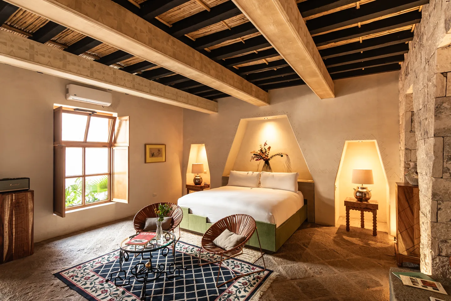 Genesis Suite bedroom with shuttered window, stone wall and seating area — La Valise San Miguel de Allende