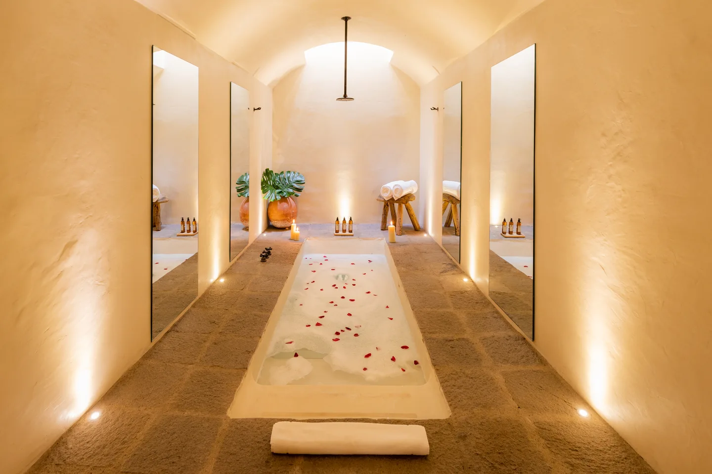 Baño hundido de inspiración mixteca con pétalos de rosa entre muros espejeados en la Genesis Suite — La Valise San Miguel de Allende