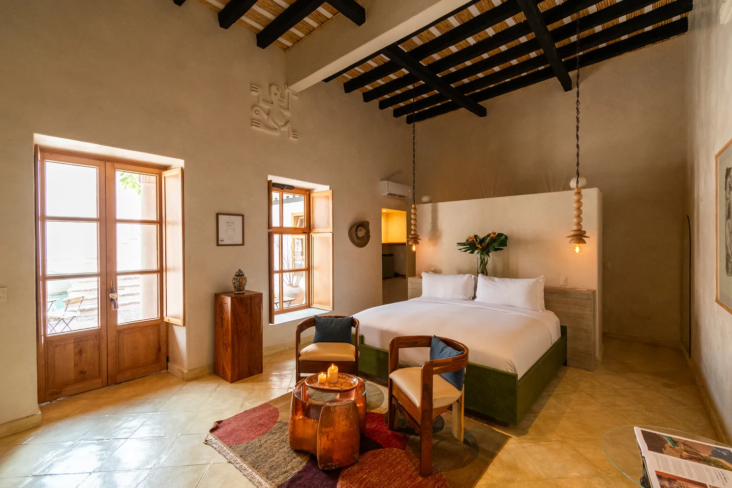 Alma Suite with French doors to the courtyard, king bed and copper side table — La Valise San Miguel de Allende