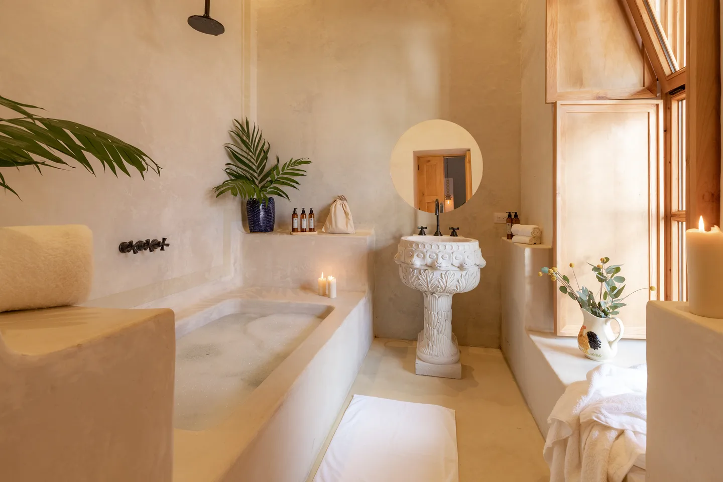 Baño de Alma Suite con tina de inmersión de yeso, lavabo de piedra tallada y regadera tipo lluvia — La Valise San Miguel de Allende