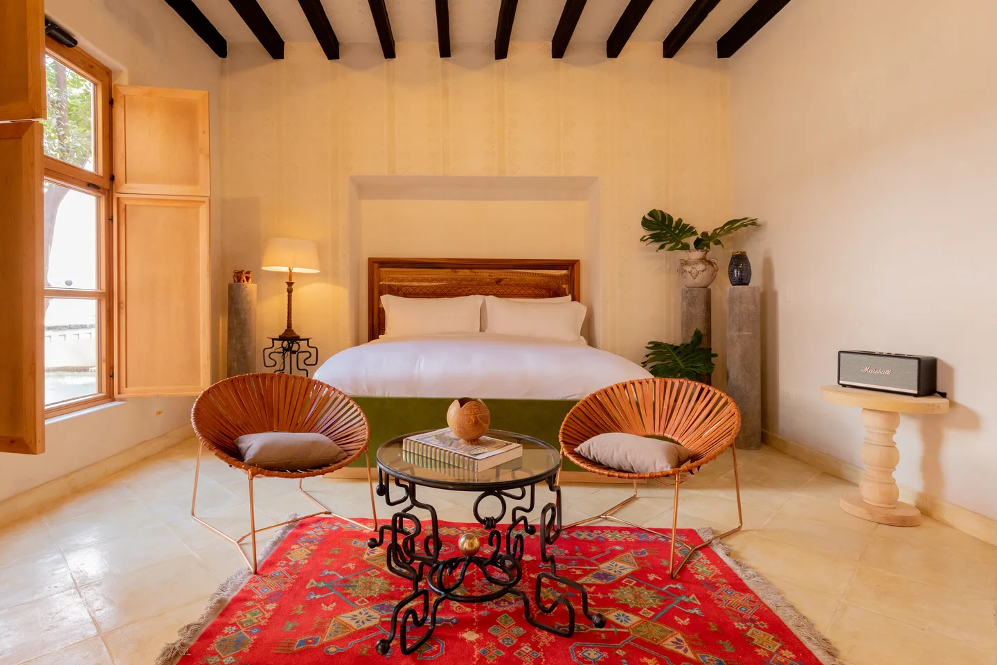 Ollín Suite con cama king, sillas Acapulco de piel, tapete rojo mexicano y techo con vigas de madera — La Valise San Miguel de Allende