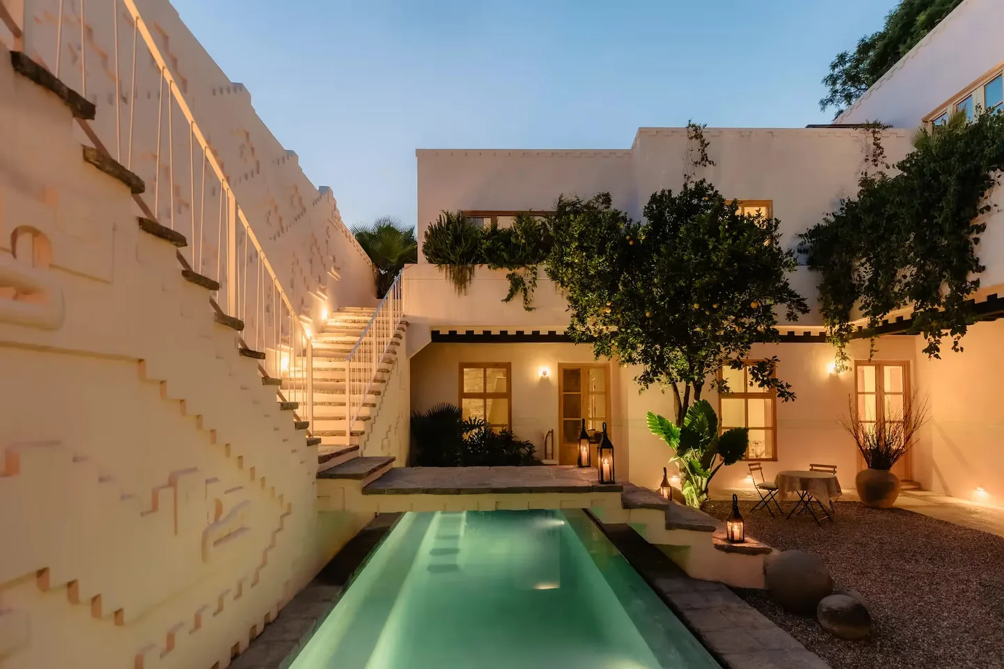 Illuminated courtyard pool at twilight beside the sculpted Chichimeca staircase at La Valise San Miguel de Allende