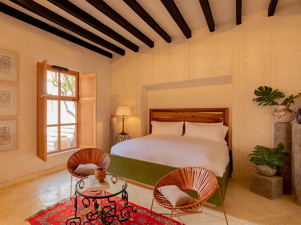 OLLÍN SUITE — La Valise San Miguel: Bedroom with a bed, chairs, and a window with a view outside.